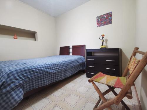 - une chambre avec un lit, une commode et une chaise dans l'établissement Habitaciones en Acogedora estancia en pleno centro de Ibagué, à Ibagué