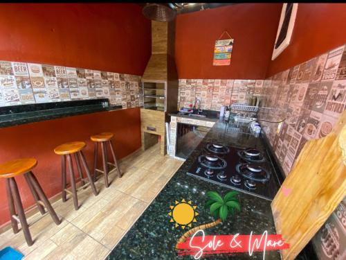 uma cozinha com fogão e alguns bancos em Casa Sole & Mare - Praias e Cachoeiras em Paraty