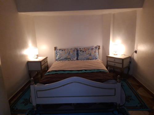 a small bedroom with a bed with two night stands at Tanger in Tangier
