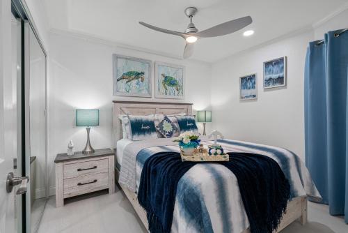 a bedroom with a bed with a blue comforter at Welcome to Sea Forever Balcony with ocean views! in Tampa