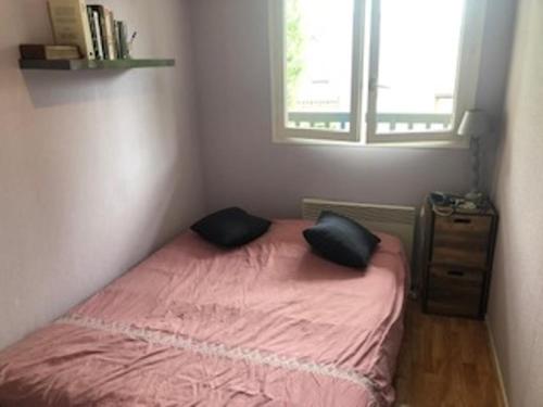 une petite chambre avec un lit rose et une fenêtre dans l'établissement Appartement à 150m de la plage, proche centre-ville et Paléospace - FR-1-712-10, à Villers-sur-Mer