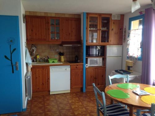 - une cuisine avec des placards en bois, une table, une table et des chaises dans l'établissement Duplex 3 pièces avec balcon à 2 pas de la plage - FR-1-712-11, à Villers-sur-Mer