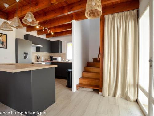 - une cuisine avec un comptoir et un escalier dans une pièce dans l'établissement LOCATION VACANCES VILLA 4 Pièces 7 personnes LA PALMYRE -Résidence les Trémières - FR-1-705-12, à La Palmyre