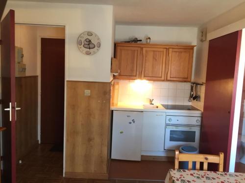 - une petite cuisine avec des appareils blancs et des armoires en bois dans l'établissement Appartement 2 Chambres Proche Plage avec Parking à Villers-sur-Mer - FR-1-712-19, à Villers-sur-Mer