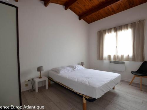 une chambre blanche avec un lit et une fenêtre dans l'établissement LOCATION VACANCES VILLA 4 Pièces 7 personnes LA PALMYRE -Résidence les Trémières - FR-1-705-12, à La Palmyre