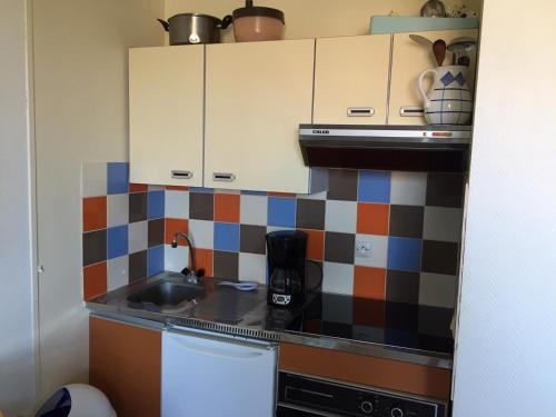 une petite cuisine avec un évier et une cuisinière dans l'établissement Appartement 2 pièces au calme avec balcon, parking, à 500m de la plage - Villers-sur-Mer - FR-1-712-21, à Villers-sur-Mer