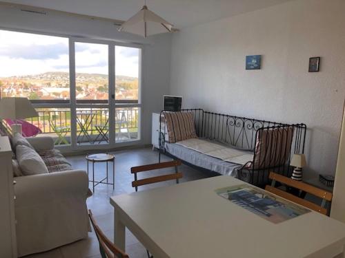 un salon avec un canapé et une table dans l'établissement Studio lumineux avec balcon, proche plage, commerces et gare, avec parking privatif - FR-1-712-33, à Villers-sur-Mer
