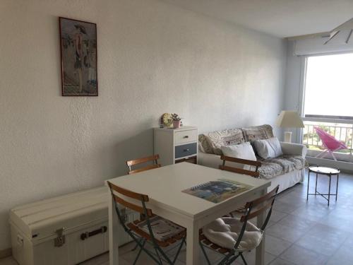 un salon avec une table et un canapé dans l'établissement Studio lumineux avec balcon, proche plage, commerces et gare, avec parking privatif - FR-1-712-33, à Villers-sur-Mer