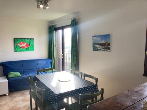 un salon avec une table et un canapé bleu dans l'établissement 3 pièces spacieux avec balcon près de la plage - FR-1-712-29, à Villers-sur-Mer