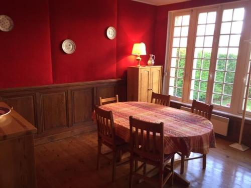 d'une salle à manger avec une table, des chaises et des murs rouges. dans l'établissement Villa proche centre et plage, 5 chambres, jardin, terrasse, parking - FR-1-712-37, à Villers-sur-Mer