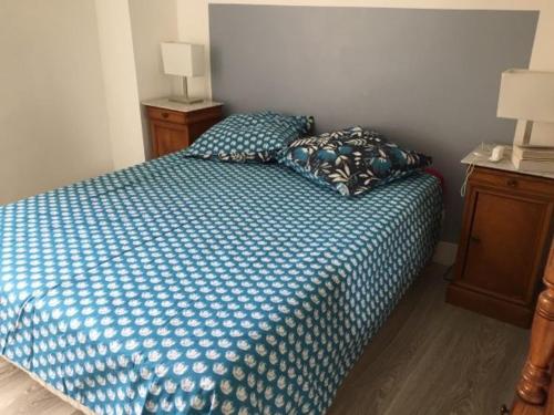 ein Schlafzimmer mit einem Bett mit blauer Bettdecke und zwei Kissen in der Unterkunft Appartement Blonville-sur-Mer, 2 pièces, 4 personnes - FR-1-712-31 in Blonville-sur-Mer