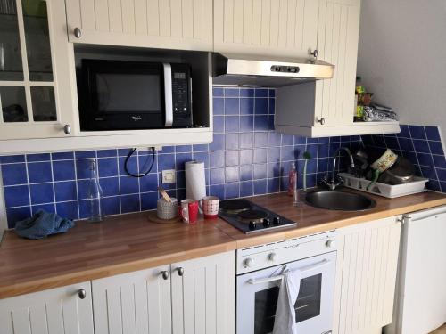 une cuisine avec un évier et un micro-ondes dans l'établissement Appartement Familial avec Balconnet, Proche Plage et Commerces - FR-1-712-41, à Villers-sur-Mer