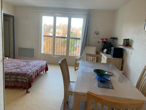 Cette chambre comprend une table, un lit et une fenêtre. dans l'établissement Appartement 2 pièces centre de Villers-sur-Mer avec parking - FR-1-712-40, à Villers-sur-Mer