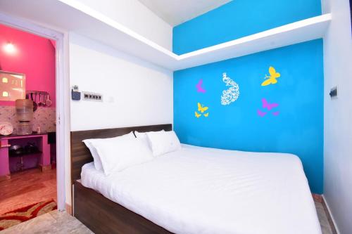 1 dormitorio con cama blanca y pared azul en Villa Betty Beach Front en Pondicherry