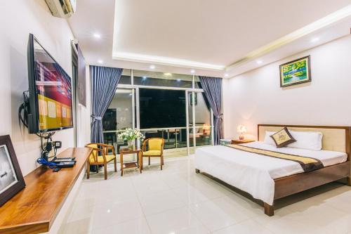 Schlafzimmer mit einem Bett, einem Schreibtisch und einem TV in der Unterkunft Villa FLC Sam Son in Sầm Sơn