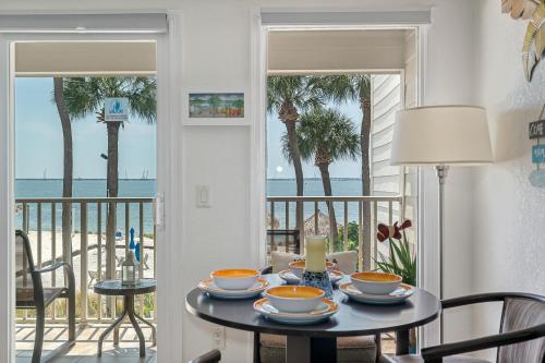 een eetkamer met een tafel en uitzicht op het strand bij Paradise Beach Sailport Resort Condo in Tampa