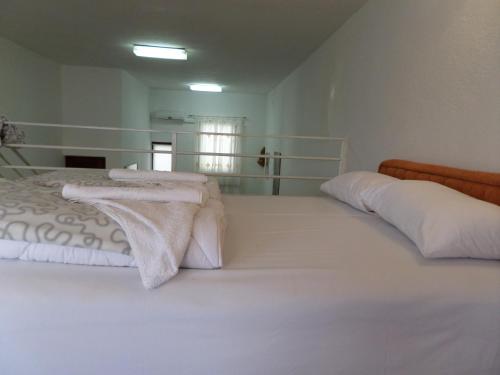 a large white bed with white sheets and pillows at Green River Apartment in Mostar
