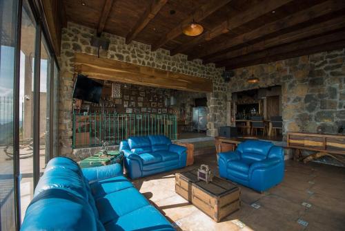 salon z niebieskimi kanapami i kamienną ścianą w obiekcie Casa de campo nubes cerca de Morelia w mieście Patámbaro