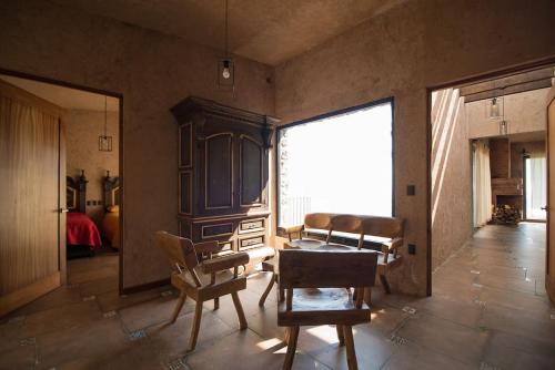 Pokój ze stołem i krzesłami oraz dużym oknem w obiekcie Casa de campo nubes cerca de Morelia w mieście Patámbaro