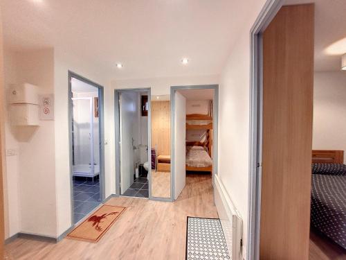 - un couloir avec une chambre dotée d'un lit et d'un miroir dans l'établissement Appartement lumineux avec balcon - 2 chambres - 5 personnes - Centre station - FR-1-275-198, à La Rosière