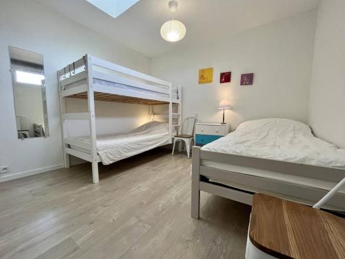 une chambre avec deux lits superposés et un bureau dans l'établissement Jolie maison rénovée 3 pièces Oléron, 4 couchages, proche plage et centre-ville - FR-1-246A-223, à La Brée-les-Bains