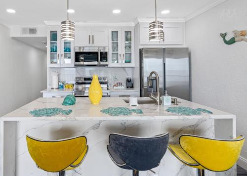 a kitchen with yellow chairs and a white counter at Bay Views from your Balcony Beach Resort Tampa in Tampa