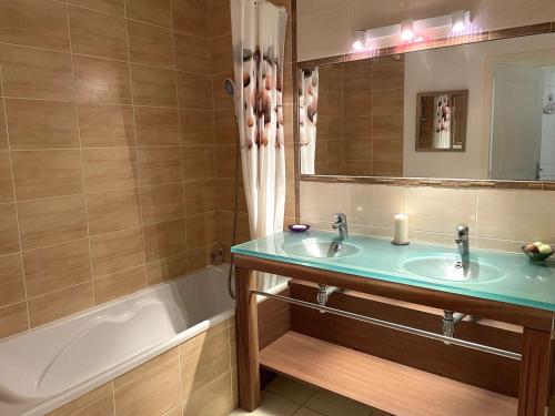 ein Badezimmer mit zwei Waschbecken, einer Badewanne und einem Spiegel in der Unterkunft Appartement L'Aiguillon-sur-Vie, 3 pièces, 6 personnes - FR-1-224-797 in LʼAiguillon-sur-Vie