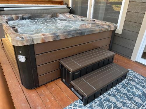 a hot tub on a deck with a bench next to it at Mins to Gburg Sleeps 8 Hot Tub Arcade Area Pool in Gatlinburg