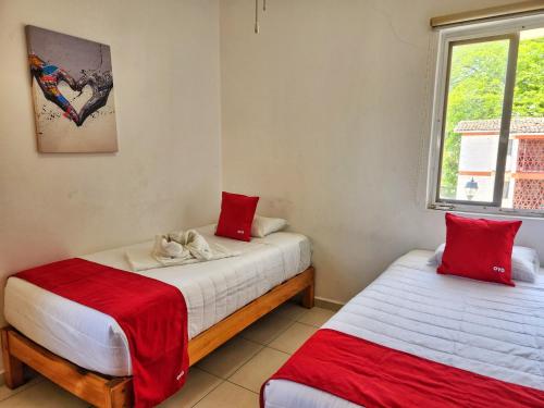 Un dormitorio con dos camas y una ventana. en Depa Calpan, en Santa Cruz Huatulco