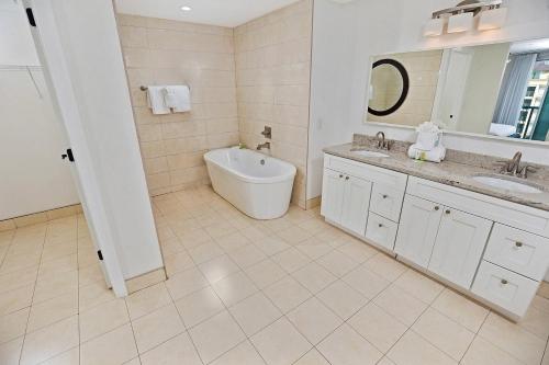 a white bathroom with a tub and a sink at Bali Bay 401 OV Myrtle Beach Hotel Room in Myrtle Beach
