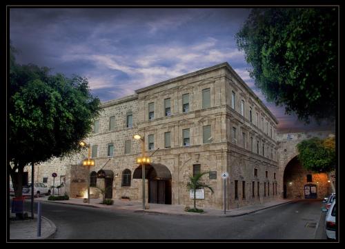 
a large building with a clock on the front of it at Akkotel-Boutique hotel in Acre
