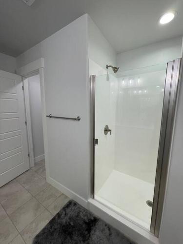 a white bathroom with a shower with a glass door at NEW 4-bed 4-bath Stylish House with Mountain View and 2 garages in Lehi