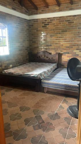 un grande letto in una stanza con muro di mattoni di PARCELA VILLA PAU a Lebrija