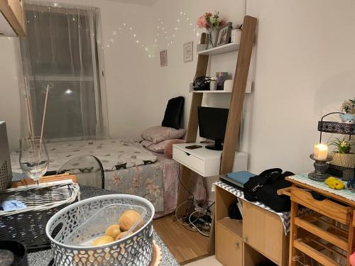 Studio flat in Stratford في لندن: غرفة صغيرة بها سرير ومكتب