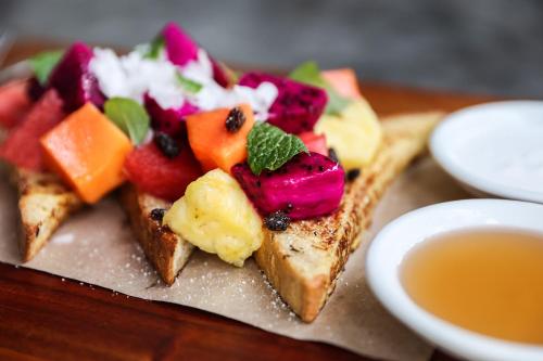 a plate of food with fruit on top of toast at Chill Hotel Seminyak in Seminyak
