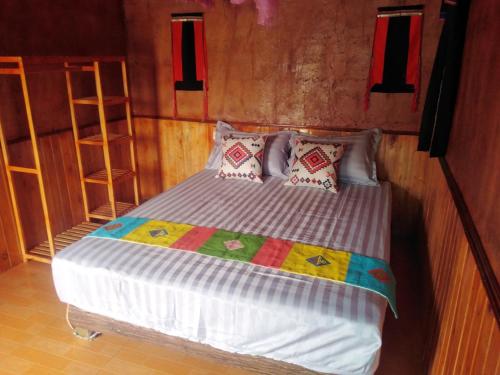 a bedroom with a bed in a room with shelves at Diềm Bungalow in Ha Giang
