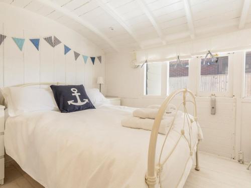 a white bedroom with a large bed and a window at Southern Bell in South Hayling