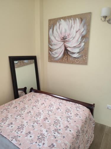 a bedroom with a bed with a flower painting on the wall at Belle Cove in Gros Islet