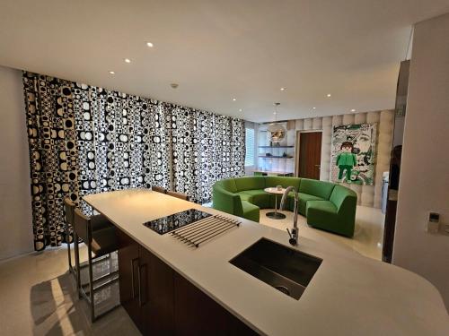 a kitchen and living room with a green couch at Chill Hotel Seminyak in Seminyak