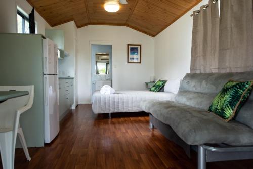 a living room with a couch and a table at Sarina Palms Caravan and Cabins Village in Sarina