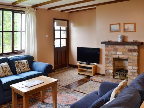 a living room with a couch and a fireplace at Jasmine Cottage in Scalby