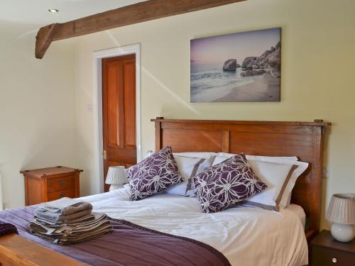 a bedroom with a bed with a wooden head board at The Granary in Lucy Cross