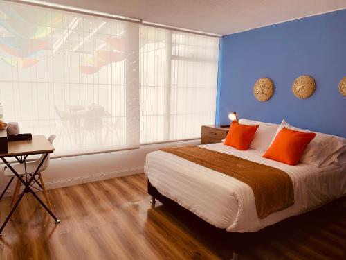 - une chambre avec un lit doté d'oreillers orange et une fenêtre dans l'établissement CASA CREAZZO 62 - Movistar Arena, à Bogotá