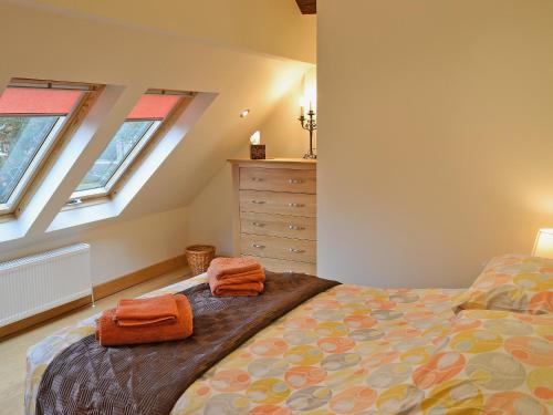 a bedroom with a bed with two towels on it at The Barn in Ropley