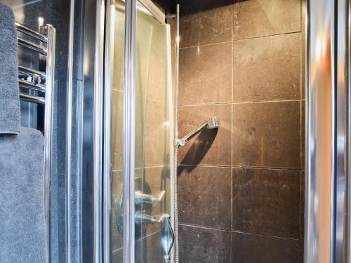een douche met een glazen deur in de badkamer bij The Barn in Ropley