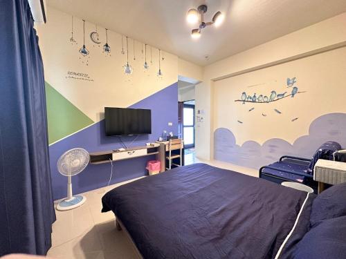 ein Schlafzimmer mit einem Bett und einem Fernseher an der Wand in der Unterkunft 樂點民宿 in Huxi