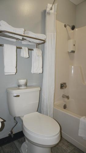 a bathroom with a white toilet and a bath tub at Lakes Inn in Warsaw