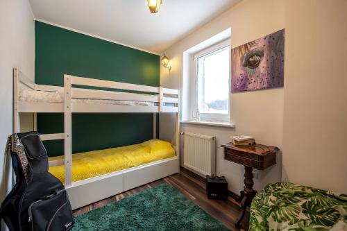 a bedroom with two bunk beds and a desk at Apartament artystyczny w rynku. in Lądek-Zdrój