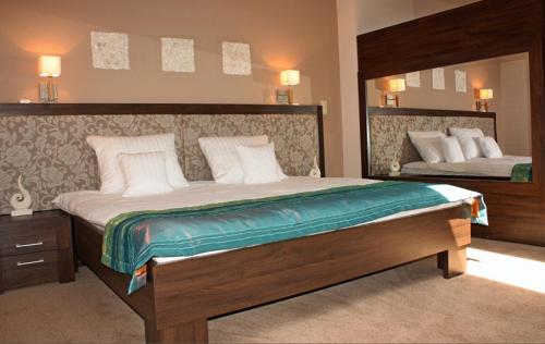a bedroom with a large bed and a mirror at Hotel Stara Kamienica in Piekary Śląskie