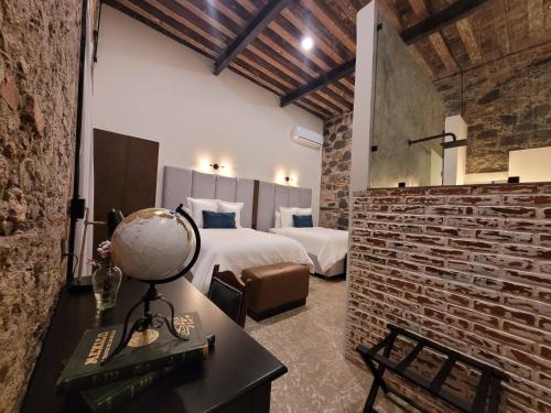 ein Hotelzimmer mit 2 Betten und einem Schreibtisch mit Globus in der Unterkunft Milo Collection Hotel in Puebla